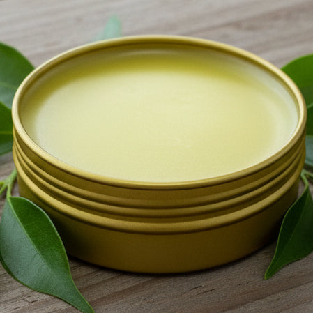 Gold metal canister of Cold Sore Salve with Manuka Honey on a textured brown surface
