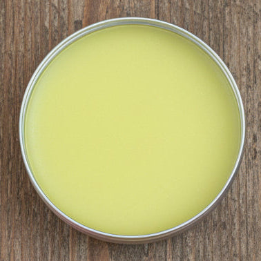 Round container with a greenish substance on a brown surface