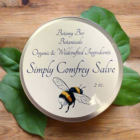 Comfrey salve container with botanical design on a wooden background