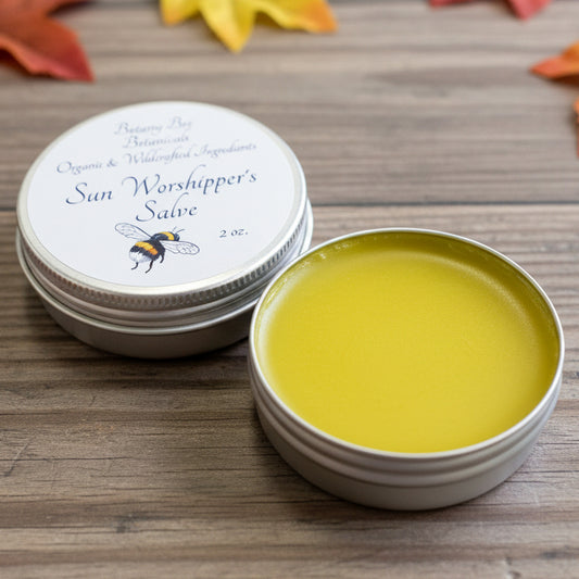 Two tins of sunscreen on a wooden surface with a plaid fabric background.