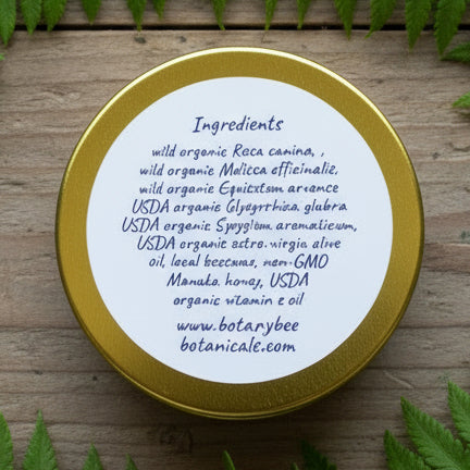 Round label with ingredient list on a gold rimmed container against a striped background