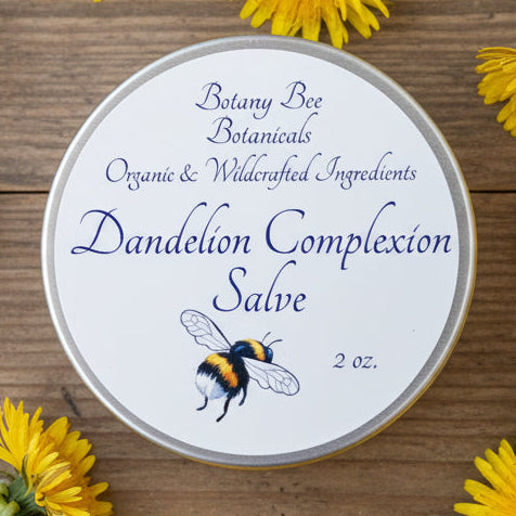 Dandelion Complexion Salve container with label and bee illustration on a wooden background