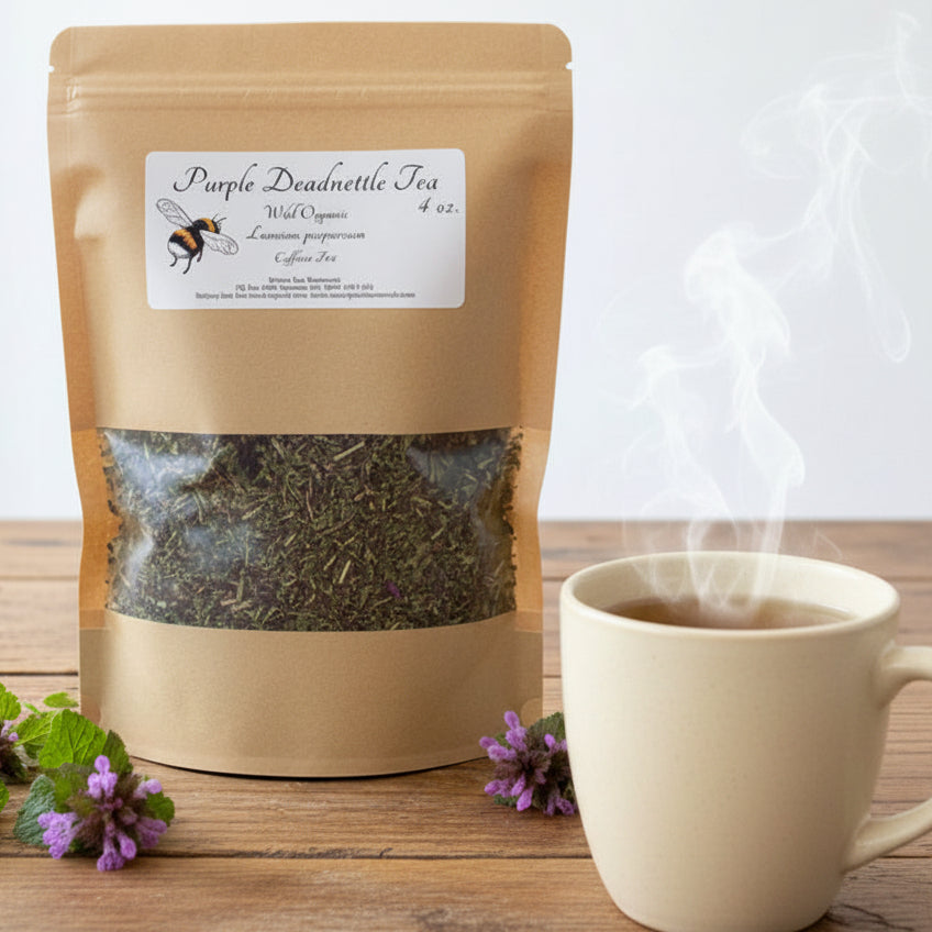 Brown paper tea bag with 'Purple Deadnettle Tea' label on a wooden surface with purple flowers.