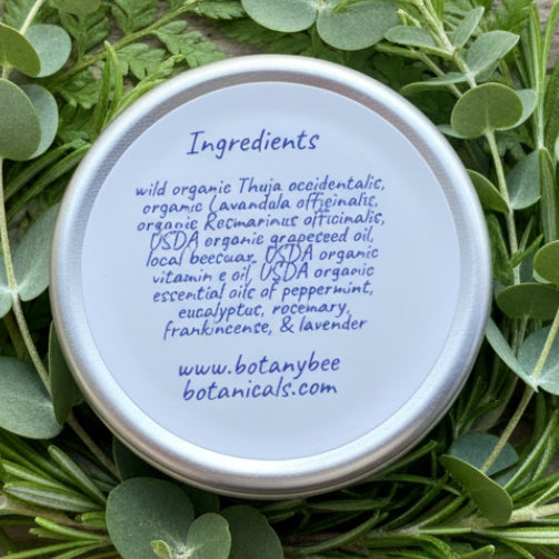 Tin lid with ingredient list and website on a wooden surface