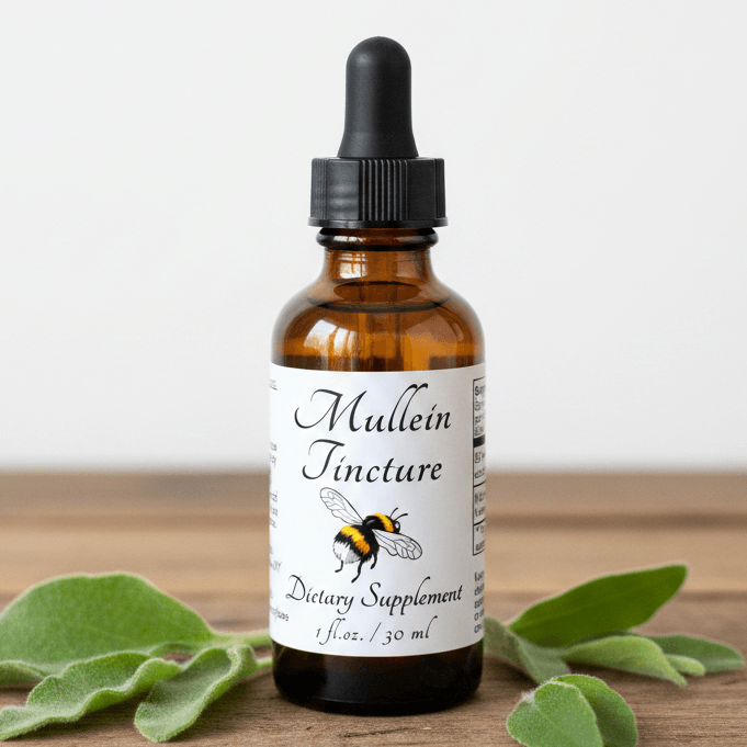 An amber glass dropper bottle labeled 'Mullein Tincture' with a black cap, standing on a wooden surface with green leaves around it against a light background.