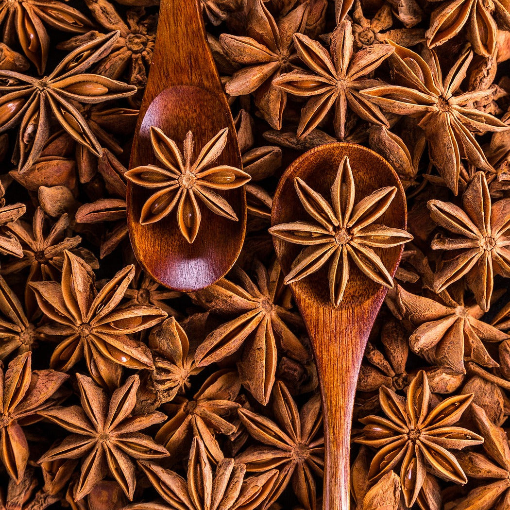 Star anise spices with wooden spoons on a background of star anise