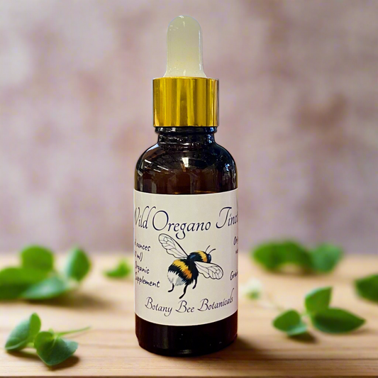 Bottle of Wild Oregano Tincture with a gold cap on a wooden surface.